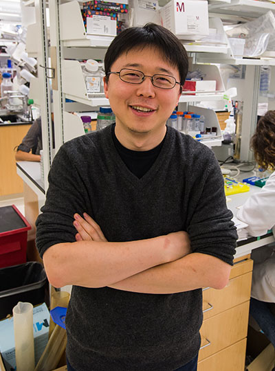 Feng Zhang with folded arms in lab