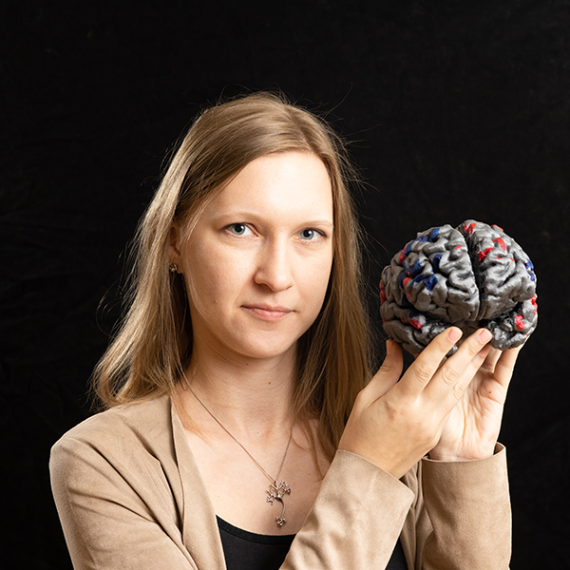 Woman holds brain and looks at camera