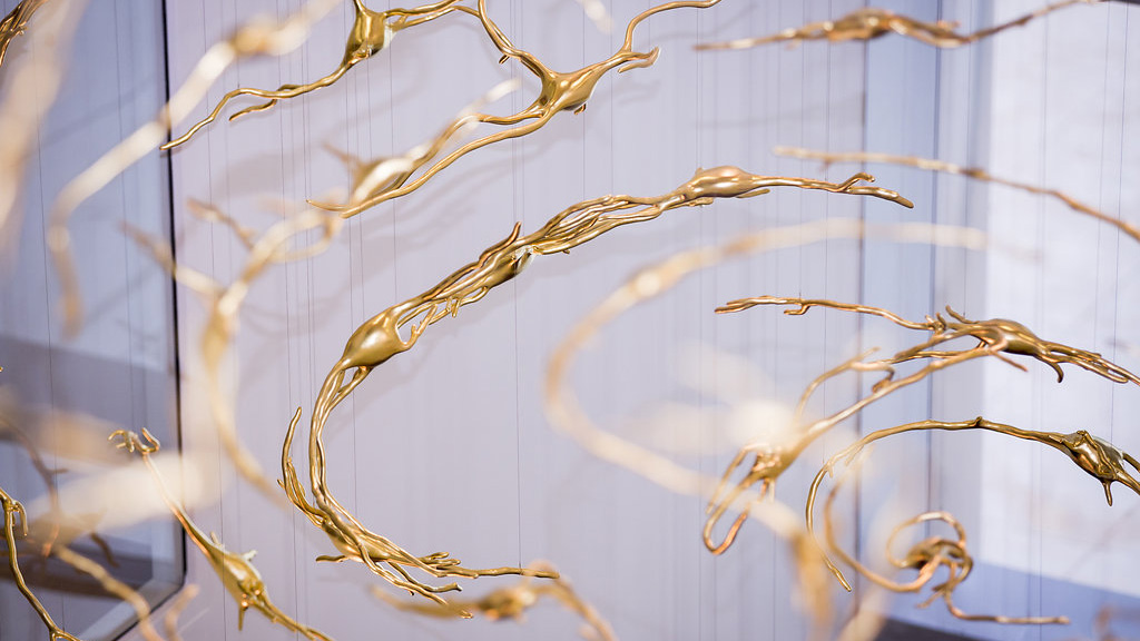 abstract gold neurons suspended from a ceiling