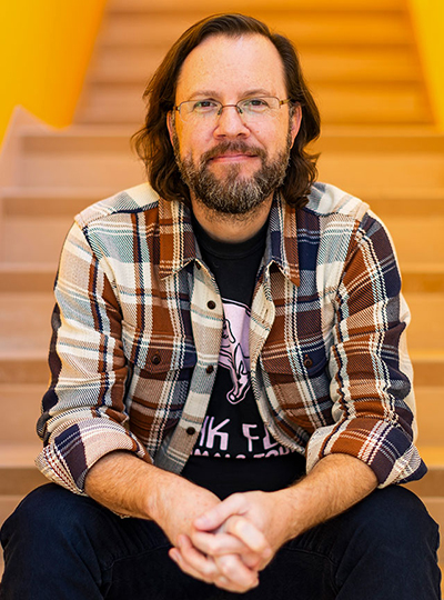 Man seated on staircase, smiling at camera
