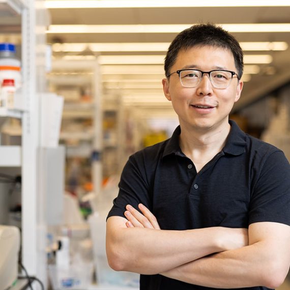Smiling scientist in a lab setting.