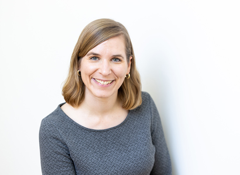 Portrait of smiling woman wearing a grey sweater. 