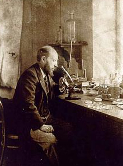 A self-portrait of Santiago Ramón y Cajal looking through a microscope.