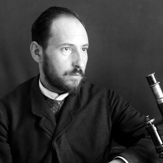 Black and white portrait of scientist Cajal at his microscope.