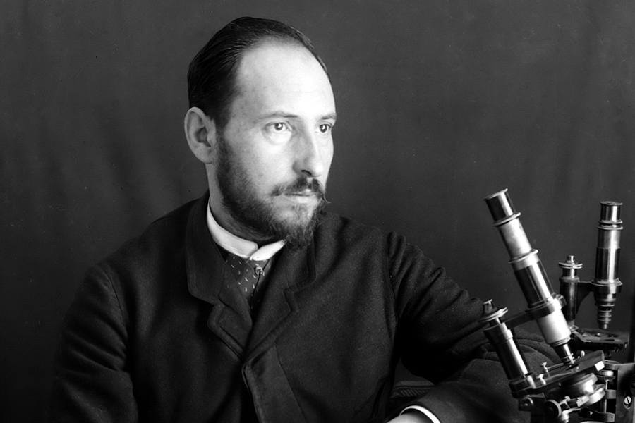 Black and white portrait of scientist Cajal at his microscope.