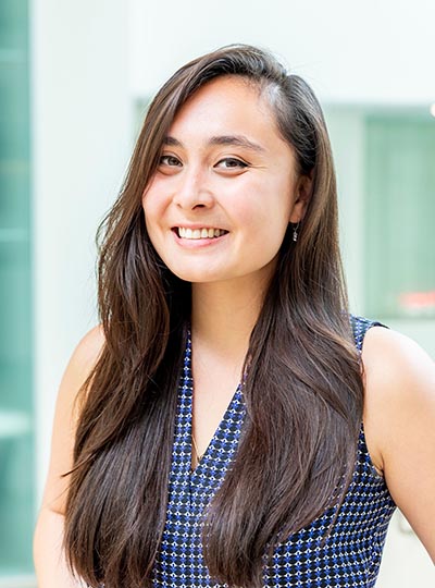 Portrait of a smiling scientist in a blue v-neck blouse.
