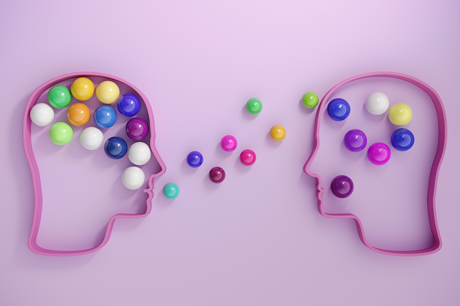 Human heads includes lots of multi colored spheres, symbolizing communication concepts. (3d render)